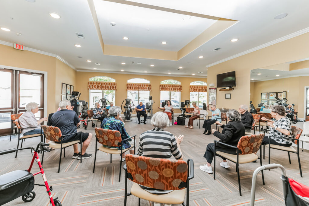 0B9A5922 - Woodhaven Village A group of residents participate in a seated exercise class in the fitness room at Woodhaven Village, a senior living community near Spring, TX.
